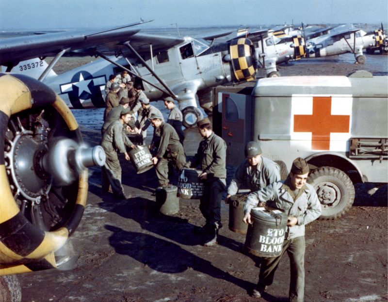 Американские солдаты выгружают контейнеры с кровью из самолета UC-64 в Нормандии. 1944 г.