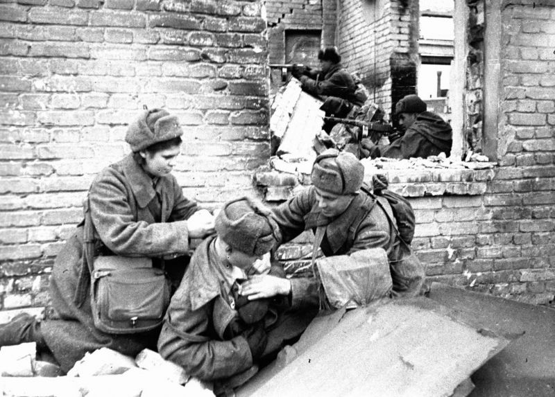 Санинструкторы Ф. Стерхов и Л. Барлина перевязывают раненого бойца в Сталинграде. 18 ноября 1942 г.