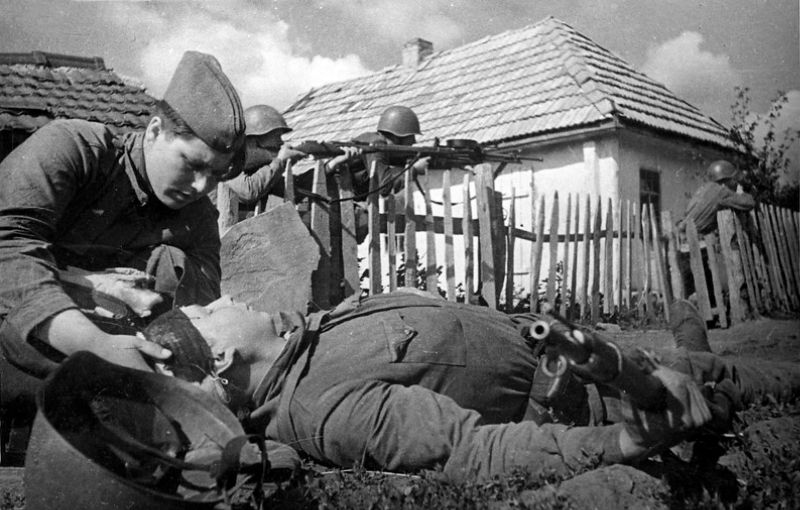 Санинструктор П. Леонтьева оказывает помощь раненому во время боя. Июль 1942 г.
