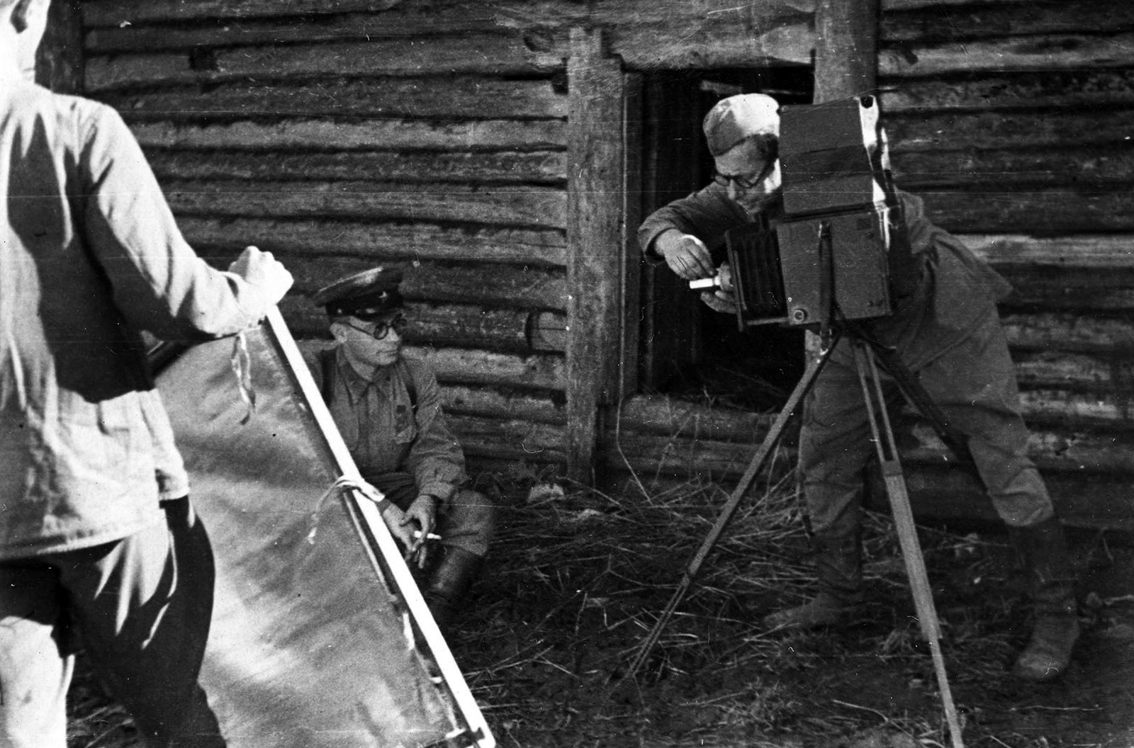 Советский военный фотокорреспондент Б.В. Игнатович готовит фотоаппарат к  съемке — военное фото