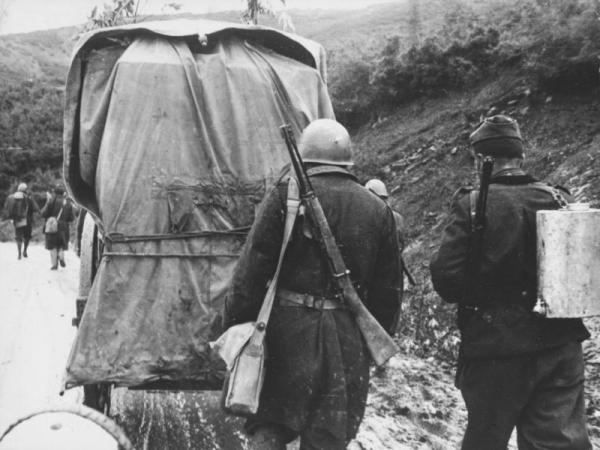  итальянских солдата, вооруженные 6,5 мм карабинами Moschetto per Cavalleria M1891 (Carcano), идут за фургоном по дороге в Албании. ВМВ