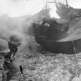 Немецкие солдаты во время боя перемещаются мимо разрушенного советского танка Т-26, уничтоженного под Ленинградом Фото